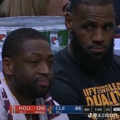 two men sitting next to each other at a basketball game