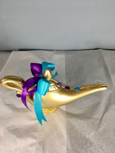 a gold and purple dragon figurine with a blue ribbon on it's head