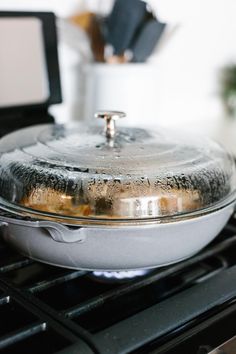 a pan sitting on top of an oven with some food cooking in it's bottom burner