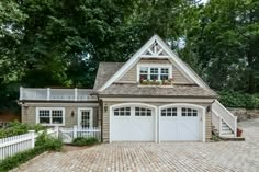 a brick driveway leading to a two car garage