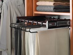 a closet with clothes hanging from it's rails and two coats on hangers