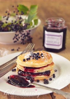 pancakes with blueberries and jam on a white plate