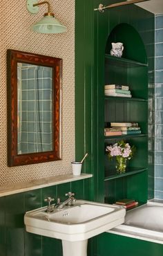 a bathroom with green walls and white fixtures