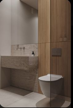 a white toilet sitting in a bathroom next to a wooden cabinet and counter with mirrors on it