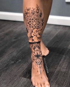 a woman's foot with flowers and leaves on the bottom part of her leg