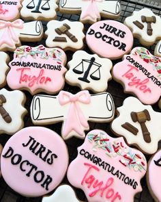 decorated cookies with pink and white icing on a cooling rack