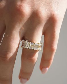 a woman's hand with a ring on it that has three baguettes