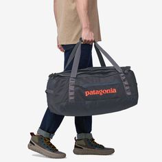 a man carrying a duffel bag with the word patagonia on it