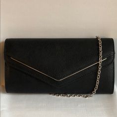 Top Flap Snap Closure Silver Tone Hardware Inside One Slide Pocket Approx. 10.5” Wide. 5.5” Height. 1” Deep Black Envelope Shoulder Bag For Everyday Use, Black Envelope Shoulder Bag For Office, Black Envelope Clutch For Daily Use, Classic Black Shoulder Bag For Party, Chic Black Envelope Bag, Black Envelope Evening Bag For Party, Classic Black Clutch For Office, Black Envelope Clutch For Formal Occasions, Classic Black Clutch For Party