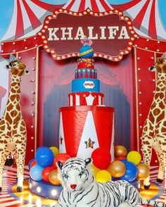 there is a cake and two giraffes in front of a circus tent