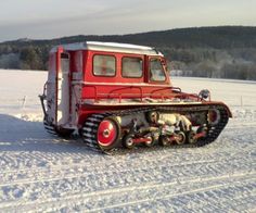 a red tractor is parked in the snow