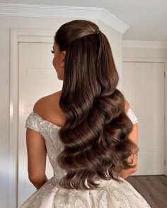 a woman with long brown hair wearing a wedding dress