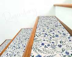 the stairs are decorated with blue flowers and green leaves on white tiles, which reads ruggaday