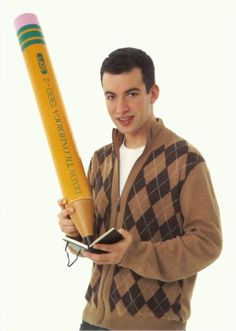 a young man holding a giant pencil in his hand