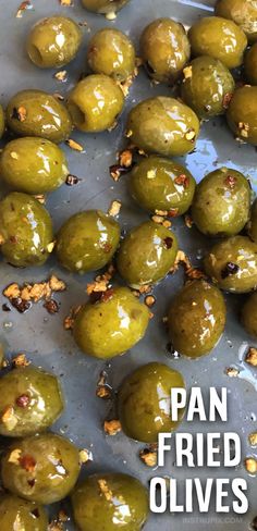 some green olives are sitting on a pan with the words pan fried olives