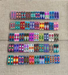 several rows of colorful bracelets are arranged on a piece of fabric, which has been stitched together