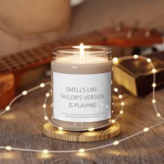 a candle sitting on top of a table next to a string of lights and a guitar