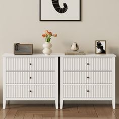 a white dresser with flowers and pictures on it