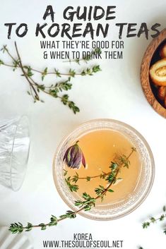 a bowl filled with food next to a cup full of tea and some herbs on the side