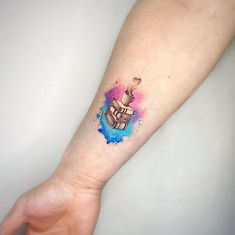 a person's arm with a small tattoo on it