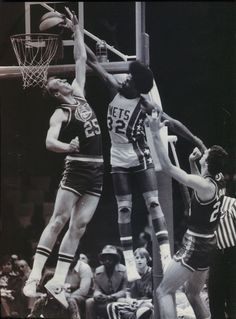 an old black and white photo of basketball players in mid air with the ball coming toward them