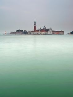 a large body of water with a building in the middle and two towers on each side