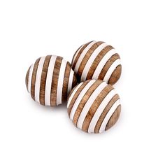 three wooden balls with white and brown stripes