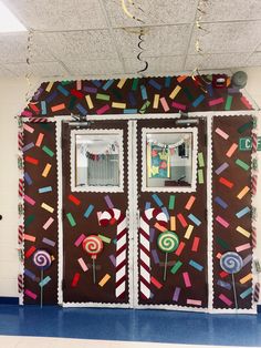 a decorated door with candy and lollipops on the front, in a school hallway