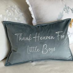 a pillow with the words thank heaven for little boys written in white ink on it