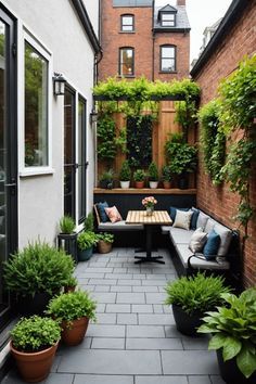 an outdoor seating area with potted plants and benches on the side of a building