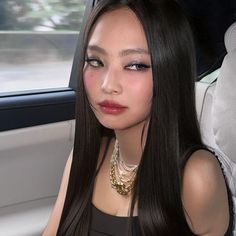 a woman with long black hair sitting in a car