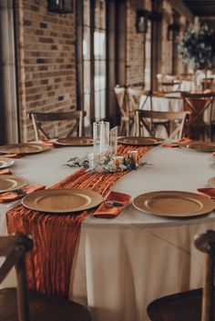 the table is set with plates and place settings