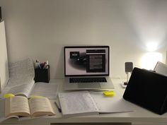 an open book sitting on top of a desk next to a computer monitor and keyboard