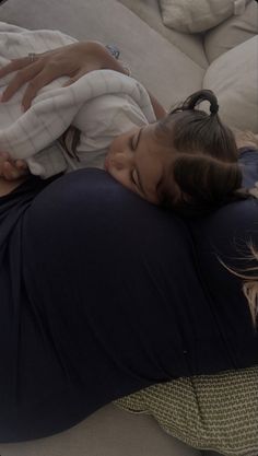 a woman laying on top of a pregnant child