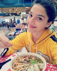 a woman sitting at a table with a bowl of food