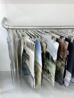 there are many pictures hanging on the clothes rack