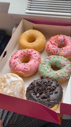 a box filled with lots of different flavored donuts