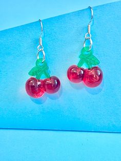 Beautiful red cherry dangle earrings. brilliant red and green colour.  The hook is made of plated sterling silver to protect your ears and the cherry is made of resin.  They come well presented and wonderful for a present for a friend, family, your loved one or a treat for you.  Thank you for taking the time to look at my earrings and please visit my shop for more original designs. Bespokedanglers.  Sharlene xx  For Fun, Funky, Quirky and original designs, please visit my shop. Bespokedanglers Cherry Dangle Earrings With Ear Wire, Trendy Red Resin Earrings, Cherry Round Earrings For Gift, Cherry Colored Round Earrings For Gift, Trendy Red Sterling Silver Jewelry, Nickel-free Red Resin Jewelry, Red Resin Drop Earrings, Cherry Colored Drop Earrings With Ear Wire, Cherry Drop Earrings With Ear Wire