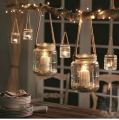 mason jars filled with candles hanging from a branch