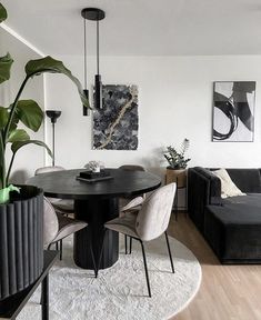 a living room filled with furniture and a large plant in the middle of the room