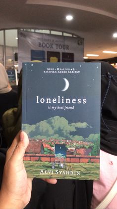 a person holding up a book in their hand with the title'loneness is my best friend '