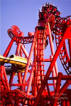 the roller coaster at six flags amusement park is painted red and yellow with purple accents