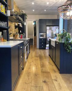 a kitchen with wooden floors and blue cabinets