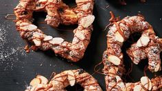 some kind of pretzel on a table with powdered sugar and chocolate toppings