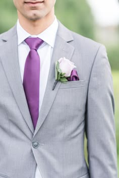 a man in a suit and tie with a boutonniere on his lapel