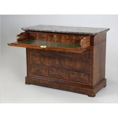 an antique desk with marble top and drawers