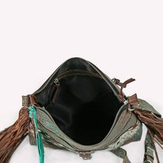 Western Boho Cowhide Crossbody Bag Step into a world of rustic elegance with our Western Boho Cowhide Crossbody Bag, designed for the free-spirited individual. Meticulously crafted with genuine cowhide and adorned with intricate turquoise color detailing, this bag offers both style and utility. Features: Authentic Cowhide Material: Each bag showcases a unique leather and cowhide pattern, making it as individual as you are. Dimensions: 12 inches in width, 12 inches in height, and 3.5 inches in de Turquoise Hand Tooled Travel Bag, Turquoise Hand Tooled Shoulder Bag For Travel, Cowhide Pattern, Turquoise Accents, Turquoise Leather, Western Design, Hand Tooled Leather, Western Boho, Free Spirited