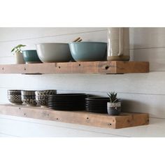 two wooden shelves with bowls and cups on them