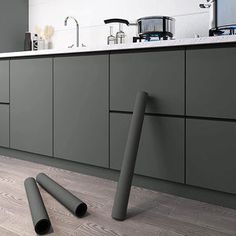 a kitchen with dark green cabinets and white counter tops, along with three black pipe handles