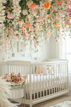 a crib with flowers hanging from the ceiling